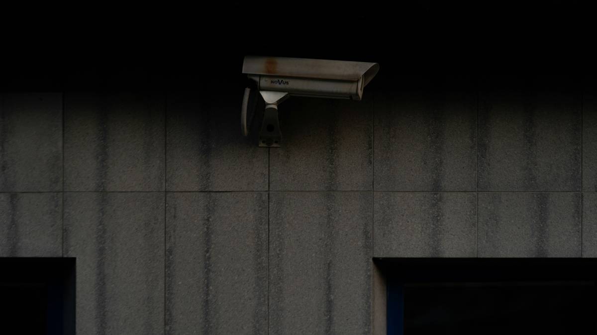 Photo of a family standing outside their secured home with smart security devices visible
