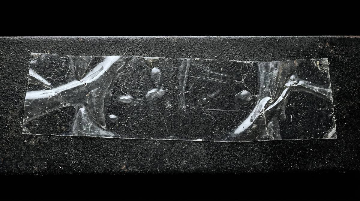 Crinkled clear tape on dark textured surface